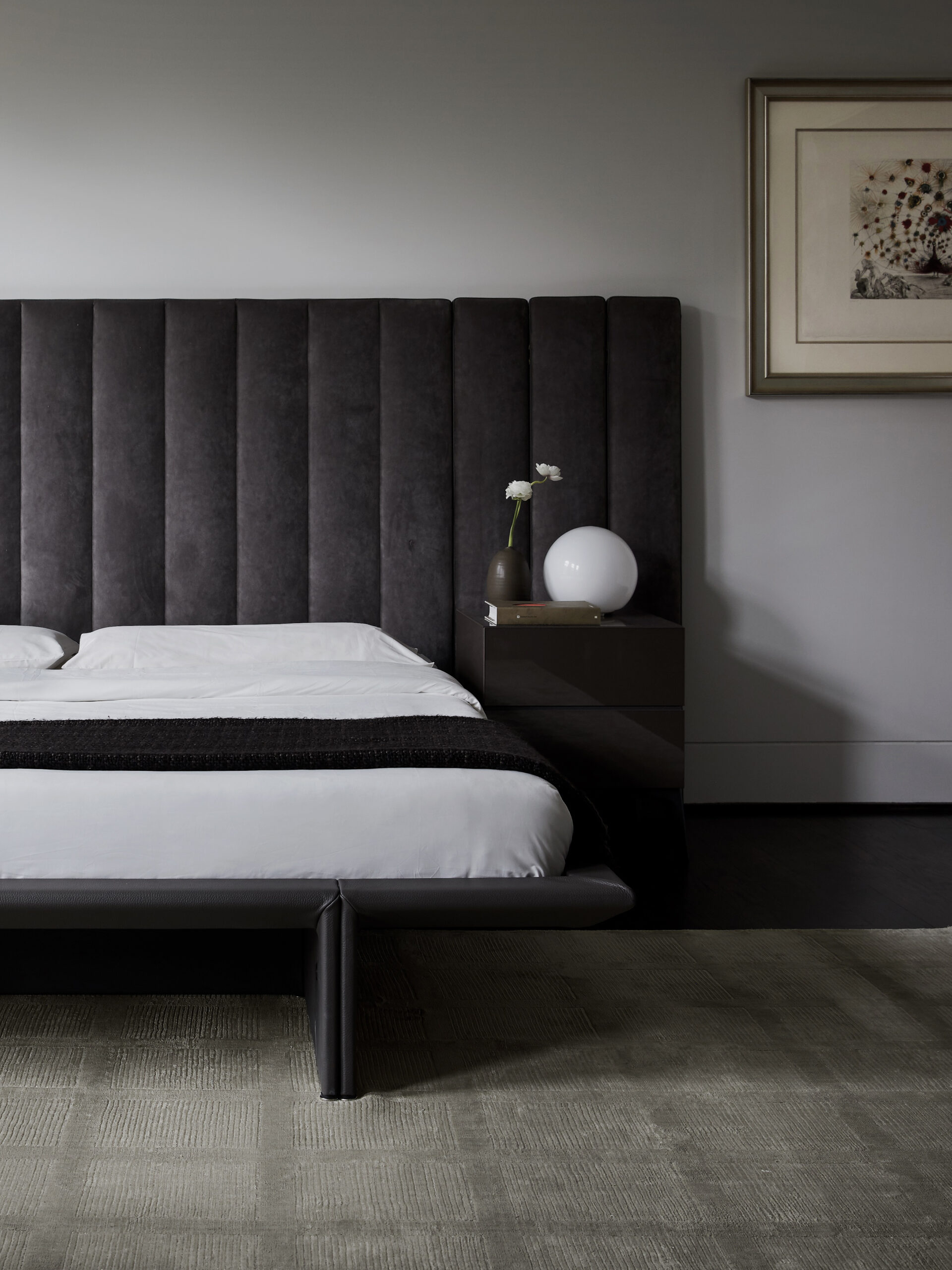 Sophisticated primary bedroom in a Houston residence by Nina Magon with a charcoal upholstered headboard, clean lines, and sculptural lighting.