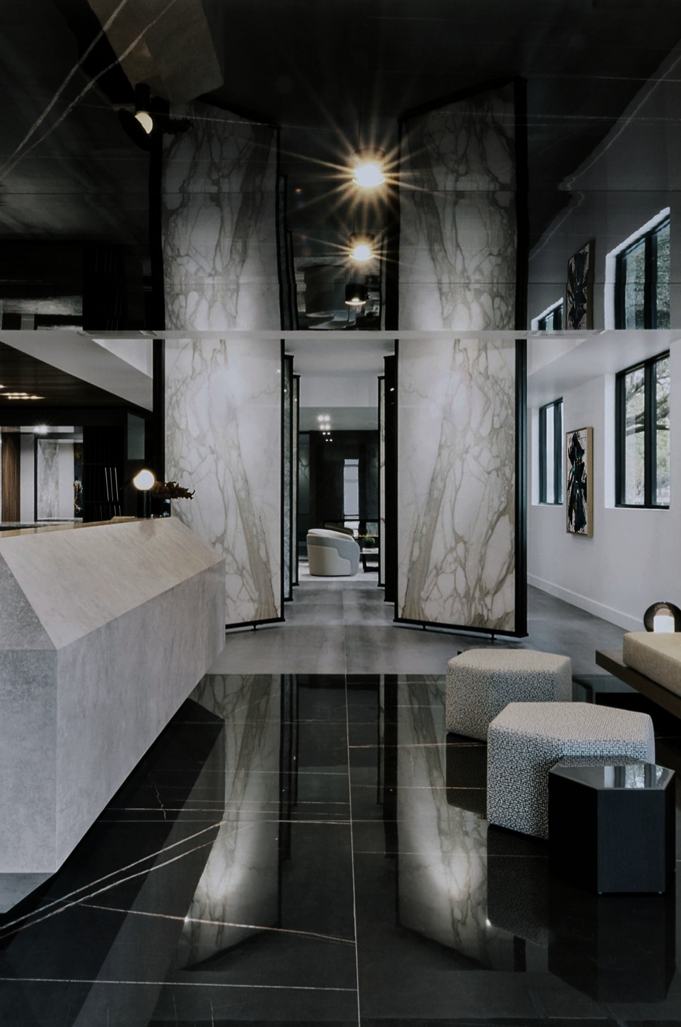 Moderno Porcelain Works designed by Nina Magon Studio showcases a luxury stone showroom with book-matched marble and reflective floors.