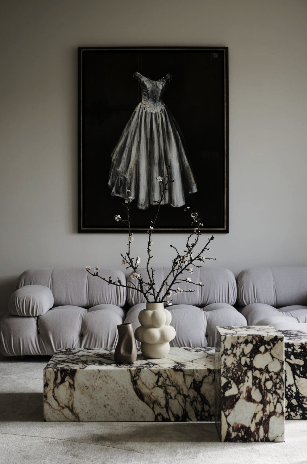 Stablewood living room by Nina Magon Studio with curved sofa, marble tables, and statement artwork.