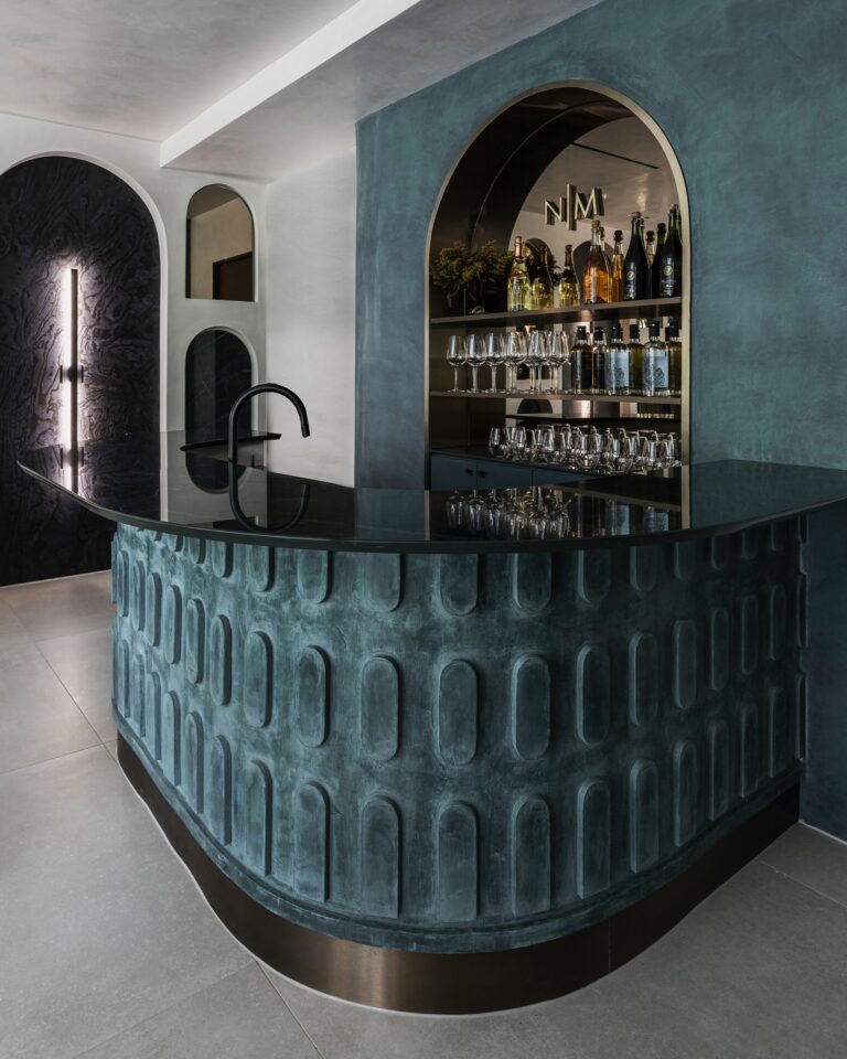 Custom finish selections by Nina Magon Studio showcasing textured plaster bar, arched niches, and bespoke material detailing