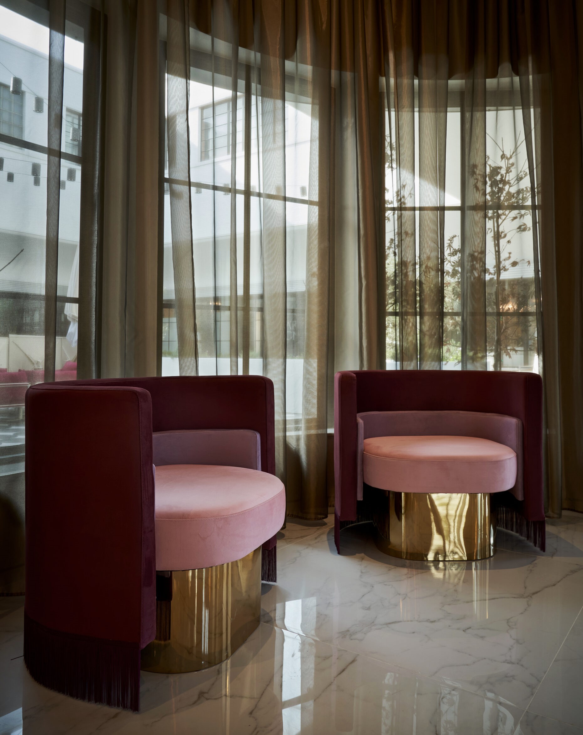 Cocody Restaurant Houston designed by Nina Magon Studio featuring sculptural blush lounge chairs with brass bases and sheer drapery in a luxury dining interior