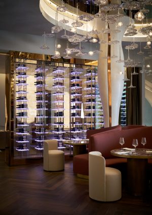 Luxury interior design management by Nina Magon Studio featuring custom wine display, statement lighting, and upscale dining design